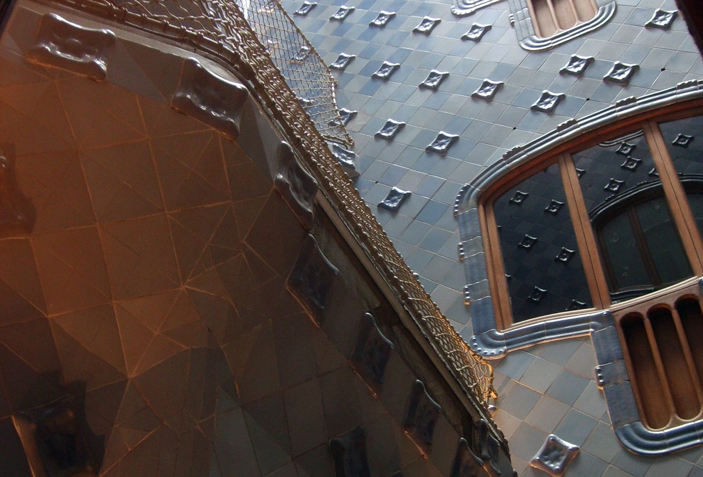 Casa Batllo roof and facade detail with ceramic surface and curved openings.