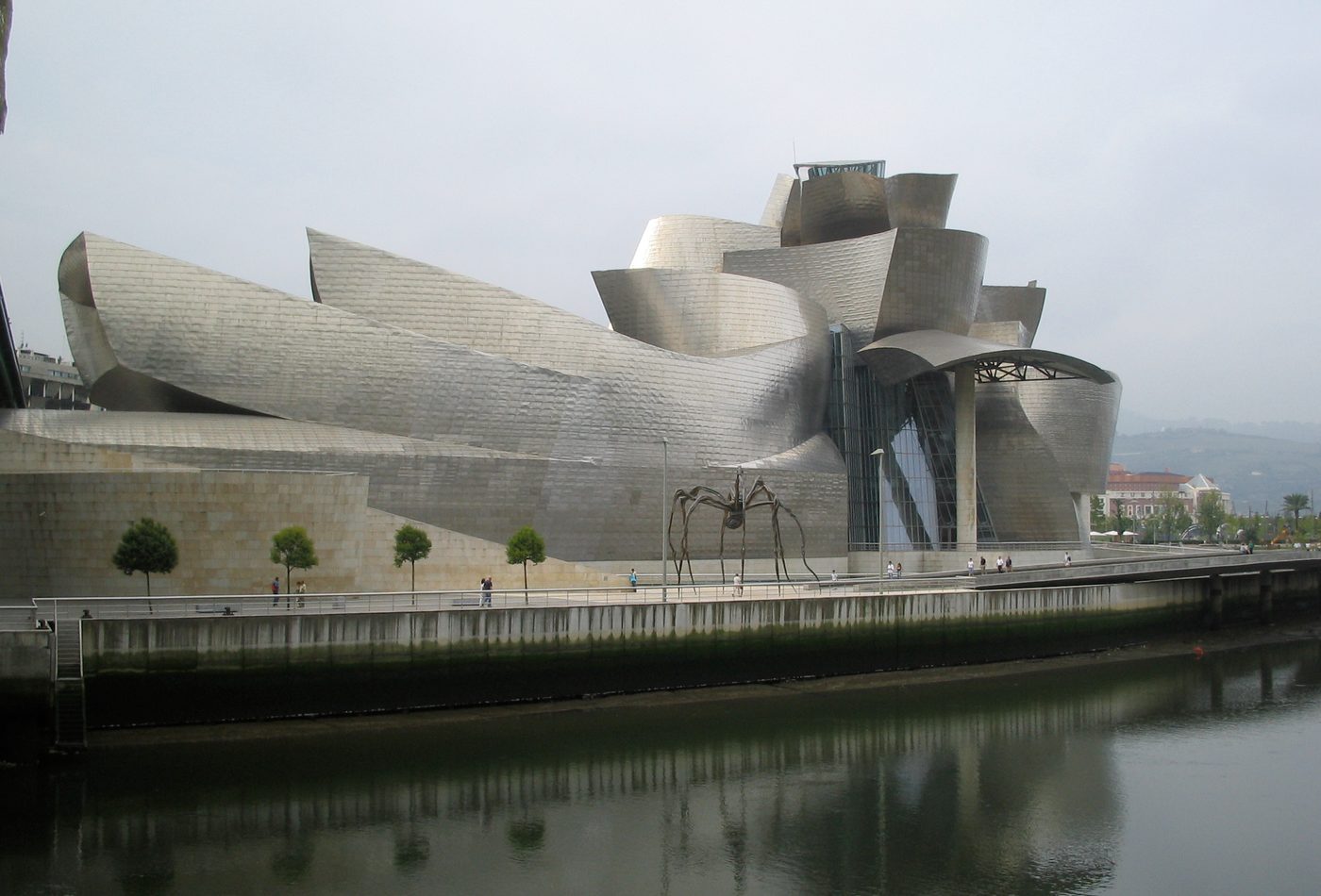 Guggenheim Museum Bilbao titanium forms reflected along the river.
